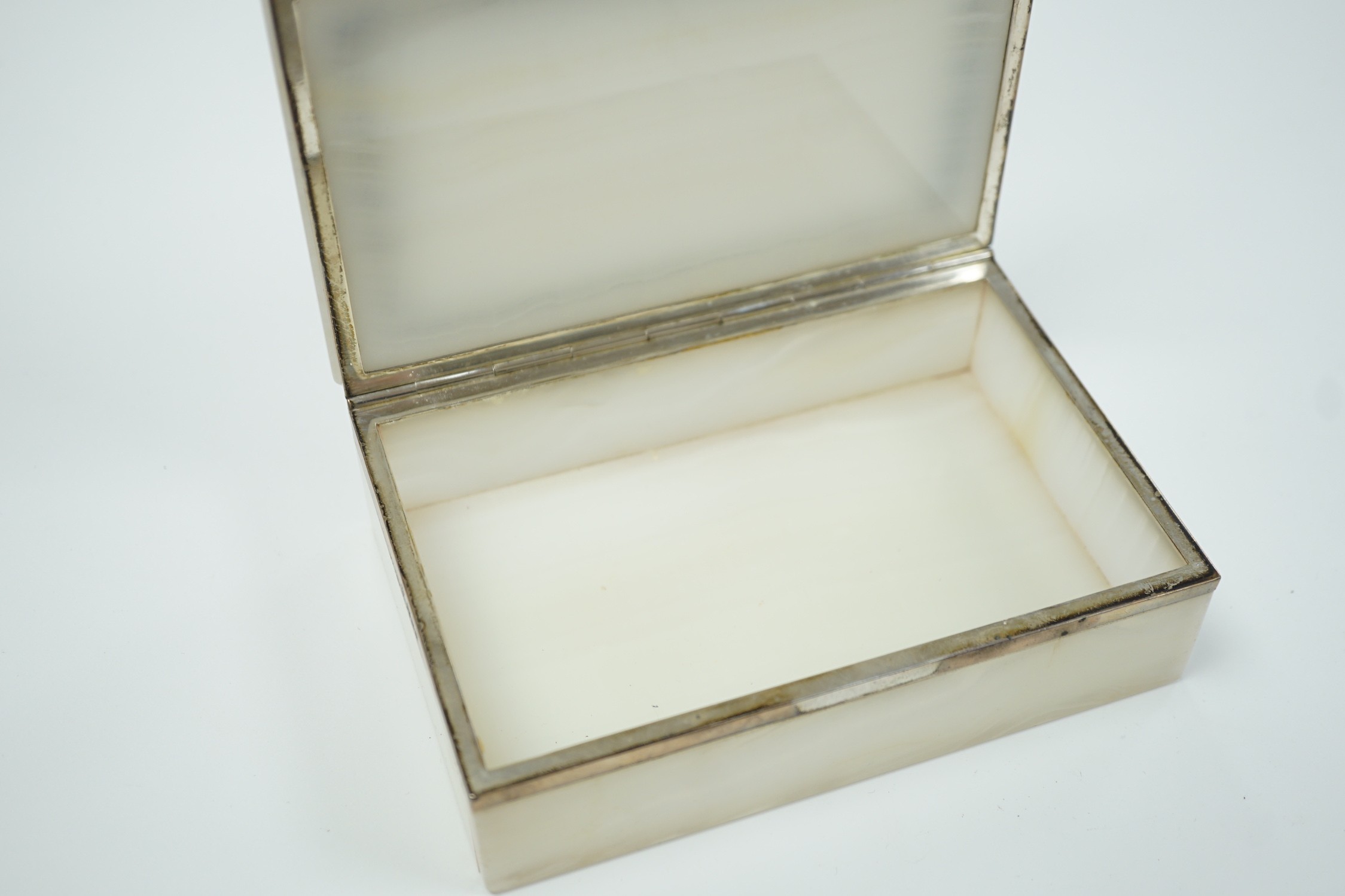 A George V silver mounted, lapis lazuli banded white onyx rectangular cigarette box, George Betjemann & Sons, London, 1919, 15.3cm.